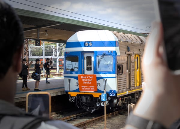Photographers capture the terminal end of V25 in its royal blue & white livery as the consist leaves Central 